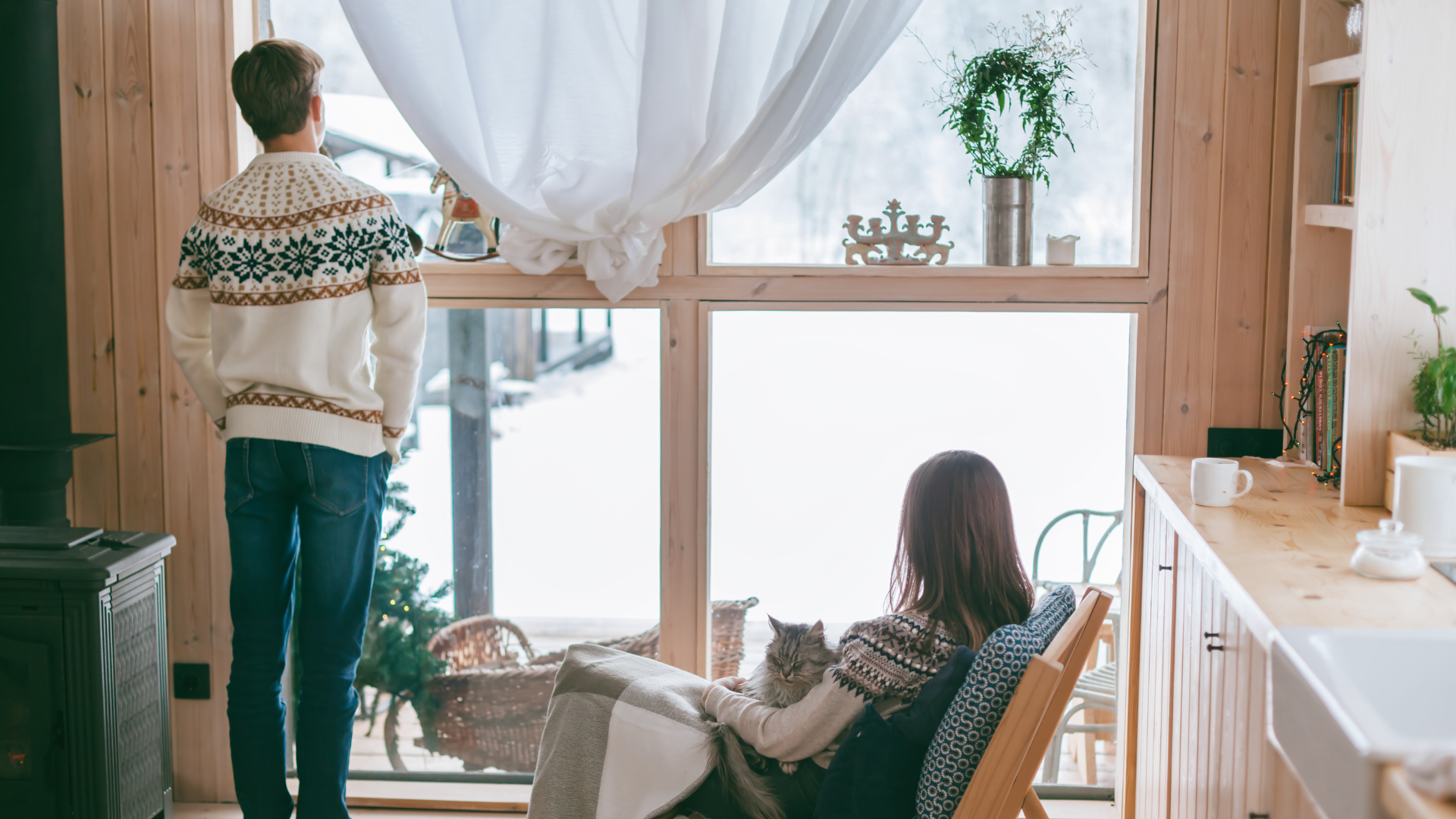 Un couple profite d'un intérieur chaleureux en hiver, soulignant l'importance de réduire sa facture d'électricité pour un confort optimal.